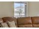 Cozy living room view features large window, mountains, and a comfortable leather sofa with pillows at 3825 Ormond Beach St # 203, Las Vegas, NV 89129