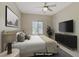 Comfortable primary bedroom features a ceiling fan, large window, and stylish, dark-colored furniture at 3825 Ormond Beach St # 203, Las Vegas, NV 89129