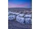 Aerial view of modern home community on hillside with breathtaking city views during twilight at 394 Solitude Peak Ln, Henderson, NV 89012