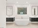 Sleek bathroom featuring a freestanding tub, dual vanities, and large mirrors at 394 Solitude Peak Ln, Henderson, NV 89012