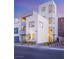 Modern multi-story white home boasts sleek lines, large windows, and inviting landscape at 394 Solitude Peak Ln, Henderson, NV 89012