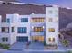 Modern home exterior featuring clean lines, multiple balconies, and glass garage doors nestled against a hillside at 394 Solitude Peak Ln, Henderson, NV 89012