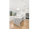 Modern kitchen with marble island, white cabinets, and built-in appliances, illuminated by pendant lighting at 394 Solitude Peak Ln, Henderson, NV 89012