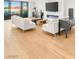 Spacious living room with hardwood floors, modern furniture, a fireplace, and sliding glass doors to a balcony at 394 Solitude Peak Ln, Henderson, NV 89012
