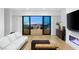 Stylish living room with hardwood floors, a fireplace, and a balcony offering city views at night at 394 Solitude Peak Ln, Henderson, NV 89012