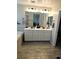 Bathroom featuring a double sink vanity with white cabinets and a large mirror with modern lighting at 4109 Cloudless Ave, North Las Vegas, NV 89081