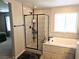 Modern bathroom featuring a glass shower and a soaking tub with stylish tile surround and neutral color palette at 4109 Cloudless Ave, North Las Vegas, NV 89081
