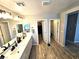 Bathroom featuring a double sink vanity with wood-look tile flooring and entry to closet and water closet at 4109 Cloudless Ave, North Las Vegas, NV 89081