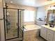 Luxurious bathroom featuring tiled shower with glass door, soaking tub, and double vanity with modern fixtures at 4109 Cloudless Ave, North Las Vegas, NV 89081
