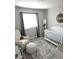 Cozy Bedroom featuring a crib, glider chair, soft rug, and neutral décor for a soothing ambiance at 4109 Cloudless Ave, North Las Vegas, NV 89081