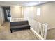 Upstairs landing with gray futon couch and white railing, featuring neutral decor and natural light at 4109 Cloudless Ave, North Las Vegas, NV 89081