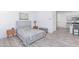 Bedroom with bed, side tables, and gray wood flooring that leads into a kitchen at 4145 Lunar Canyon Ave, North Las Vegas, NV 89084