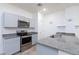 Modern kitchen with granite countertops, stainless steel appliances, and gray cabinets at 4145 Lunar Canyon Ave, North Las Vegas, NV 89084
