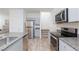 Modern kitchen with granite countertops, stainless steel appliances, and gray wood flooring at 4145 Lunar Canyon Ave, North Las Vegas, NV 89084