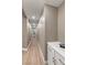 Long hallway leading to bathroom, featuring recessed lighting, white baseboards, and luxury vinyl plank flooring at 4193 Solace St # 4193, Las Vegas, NV 89135