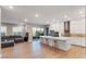 Open floor plan with a modern kitchen featuring an island with seating, stainless steel appliances and wood floors at 4193 Solace St # 4193, Las Vegas, NV 89135