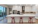 Modern kitchen island with white countertop, red stools, and stainless steel appliances in open layout at 4193 Solace St # 4193, Las Vegas, NV 89135