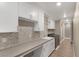 Well-lit laundry room with modern cabinets, solid surface counters, sink, designer backsplash, and front load washer and dryer at 4193 Solace St # 4193, Las Vegas, NV 89135