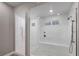 Bright tile shower features a glass door, shower head, tile surround, and a built-in bench at 4193 Solace St # 4193, Las Vegas, NV 89135