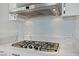 The kitchen features a modern stainless steel gas cooktop, white cabinets and mosaic tile backsplash at 4575 Dean Martin Dr # 1208, Las Vegas, NV 89103