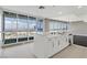 Modern kitchen with a central island, white cabinets, and large windows showcasing expansive city views at 4575 Dean Martin Dr # 1208, Las Vegas, NV 89103