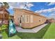 Landscaped backyard with a play structure, artificial grass, and walking paths at 4878 Friar Tuck Ave, Las Vegas, NV 89130