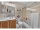 Bathroom with a single sink vanity, toilet, and shower-tub combination with a glass door at 4878 Friar Tuck Ave, Las Vegas, NV 89130