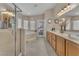 Well-lit bathroom featuring a soaking tub, glass enclosed shower and double sink vanity with wood cabinets at 4878 Friar Tuck Ave, Las Vegas, NV 89130