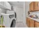 Functional laundry room featuring a front-load washer and dryer, ample storage, and a utility sink at 4878 Friar Tuck Ave, Las Vegas, NV 89130