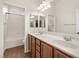 Bright bathroom featuring double sinks, wood cabinets, and shower-tub combo at 5265 Lucca Ln, Pahrump, NV 89061