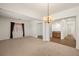 Bright living room featuring a chandelier, neutral carpet, and a view of the kitchen at 5265 Lucca Ln, Pahrump, NV 89061