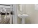 Stylish half-bathroom with pedestal sink and access to the living room at 5419 Holding Ave, Las Vegas, NV 89139