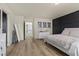 Bright bedroom with hardwood floors, modern decor, and stylish black accent wall at 5419 Holding Ave, Las Vegas, NV 89139