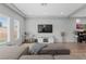 Modern living room featuring a sectional sofa, entertainment center, and large windows for plenty of natural light at 5419 Holding Ave, Las Vegas, NV 89139