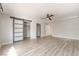 Large bedroom features wood-look floors, with a ceiling fan and frosted sliding closet doors at 5612 Coder Ct, Las Vegas, NV 89118