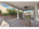 Cozy covered patio features a ceiling fan, stone flooring, grill, and separate seating area with fire pit at 6331 Regina Ridge St, Las Vegas, NV 89149