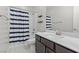 Bathroom with a shower-tub combo, modern vanity, and striped shower curtain at 6331 Regina Ridge St, Las Vegas, NV 89149