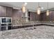 Gourmet kitchen featuring granite countertops, stainless steel appliances, custom cabinetry, and mosaic backsplash at 6331 Regina Ridge St, Las Vegas, NV 89149