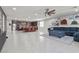 An open-concept living space flows into an eat-in kitchen, featuring tile flooring and a blue sectional sofa at 6331 Regina Ridge St, Las Vegas, NV 89149
