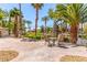 Charming outdoor patio featuring a table and chairs, surrounded by lush greenery and palm trees at 6480 Annie Oakley Dr # 814, Las Vegas, NV 89120