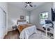 Cozy bedroom with hardwood floors, a ceiling fan, and a dedicated workspace by the window at 669 Assurance Pl, Henderson, NV 89011