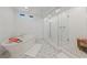 Bright bathroom featuring a soaking tub, modern shower with glass enclosure, and stylish tile flooring at 7058 W Camero Ave, Las Vegas, NV 89113