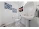 Charming half-bath with pedestal sink, patterned floor, and decorative art at 7058 W Camero Ave, Las Vegas, NV 89113