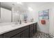 Well-lit bathroom with a large mirror, modern vanity, and stylish tile flooring, offering a clean aesthetic at 7058 W Camero Ave, Las Vegas, NV 89113