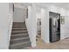 Bright entryway with staircase, side-by-side refrigerator, and access to the half bath at 7058 W Camero Ave, Las Vegas, NV 89113