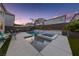 Inviting backyard pool with a spa, waterfall feature, and outdoor dining area set against a twilight sky at 7058 W Camero Ave, Las Vegas, NV 89113