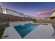 Outdoor pool with spa and waterfall feature, landscaped surroundings, set beneath a beautiful twilight sky at 7058 W Camero Ave, Las Vegas, NV 89113