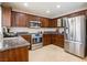 Well-equipped kitchen with stainless steel appliances, granite countertops, and dark wood cabinetry at 723 Seclusion Glen Ave, Las Vegas, NV 89123