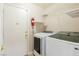 Bright laundry room with a washer, dryer, shelving, and a fire extinguisher for added safety and convenience at 723 Seclusion Glen Ave, Las Vegas, NV 89123