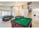 Open living area with pool table, comfortable sofas, stairs, and tiled flooring at 723 Seclusion Glen Ave, Las Vegas, NV 89123